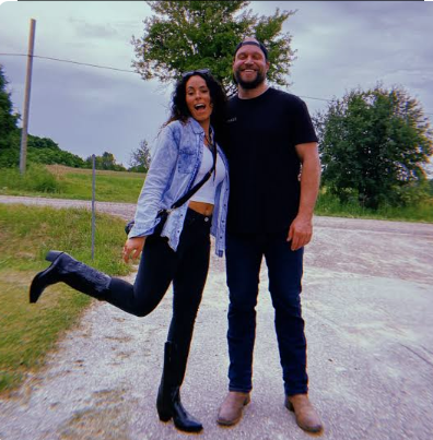 Furious Pete wife Melissa Czerwinski posing playfully in boots with Peter Czerwinski on a rural road.