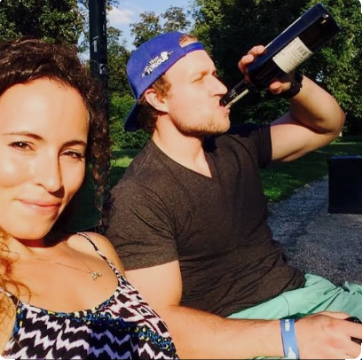 Furious Pete wife Melissa Czerwinski smiling outdoors with Pete drinking from a bottle during a fitness lifestyle vlog
